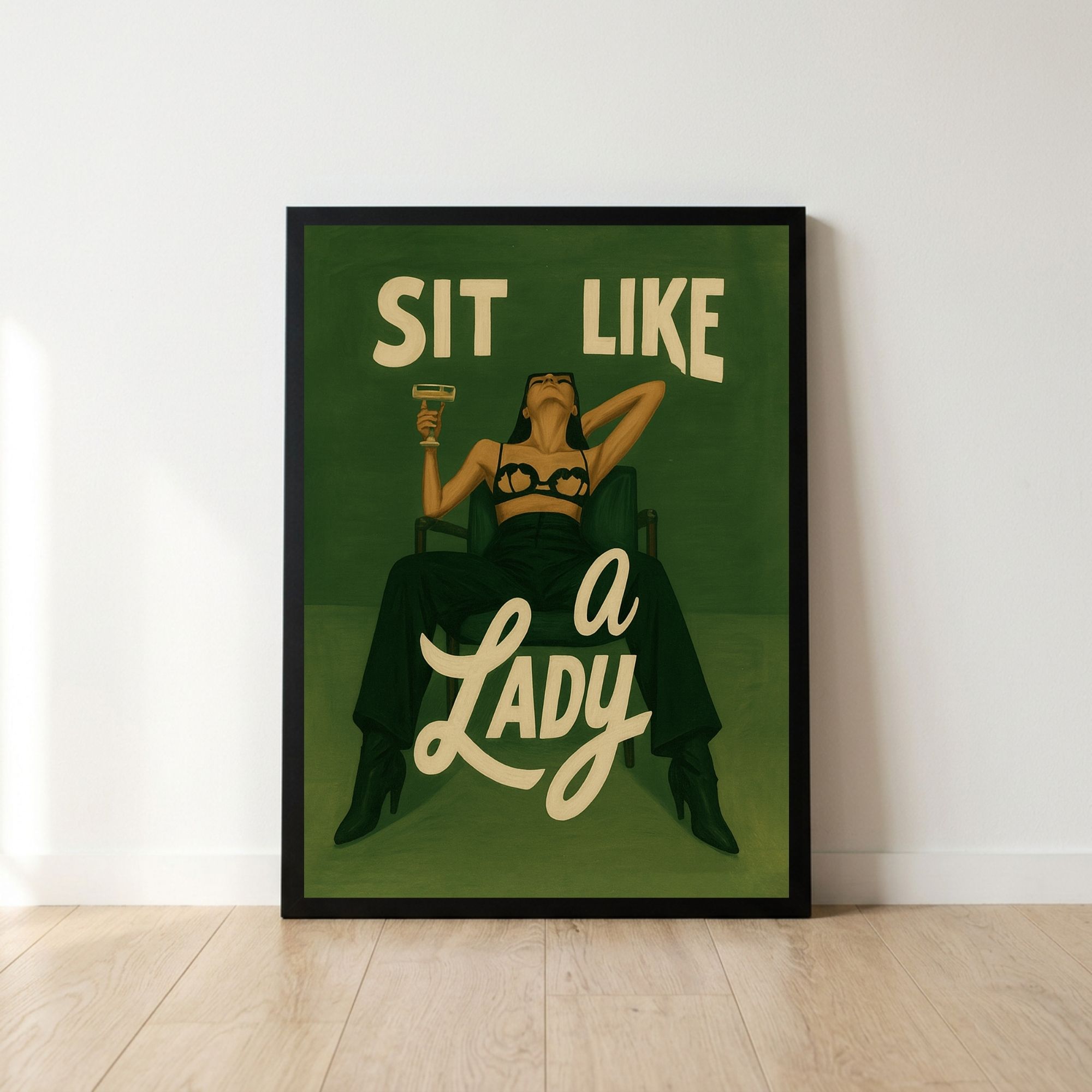bold-feminine-poster-in-a-black-frameleaning-on-wall-with-wooden-floor