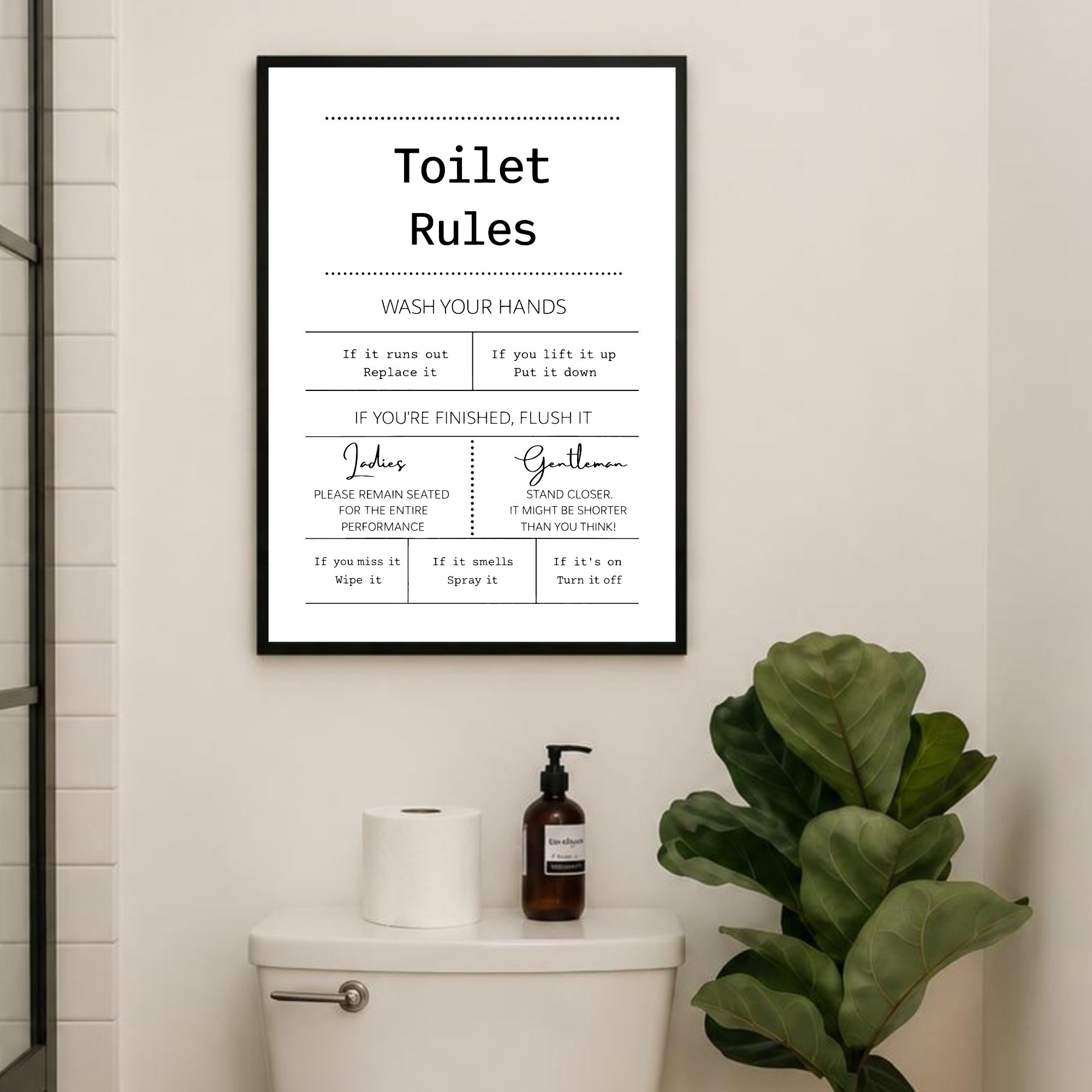 typography toilet rule poster in a black frame hanging abover toilet